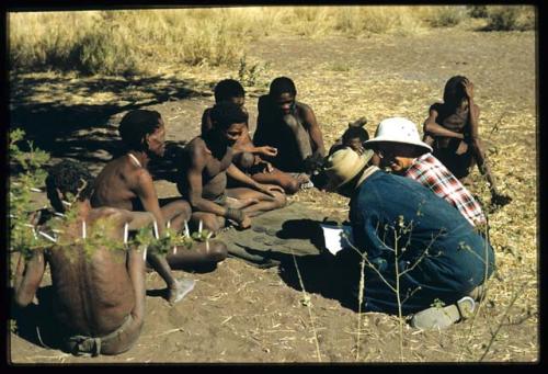 Expedition, Ethnographic work: Group of people throwing oracle disks, with Laurence Marshall and Kernel Ledimo taking notes