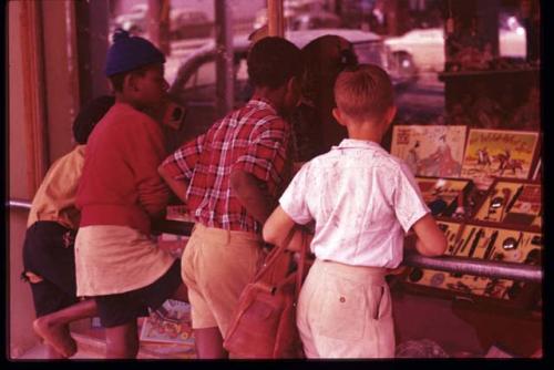 Two black boys and one white boy looking into a store window