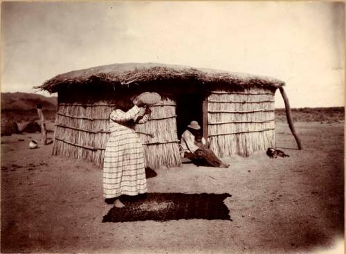 Papago Near Tucson 1900. Granary, woman pouring grain onto cloth