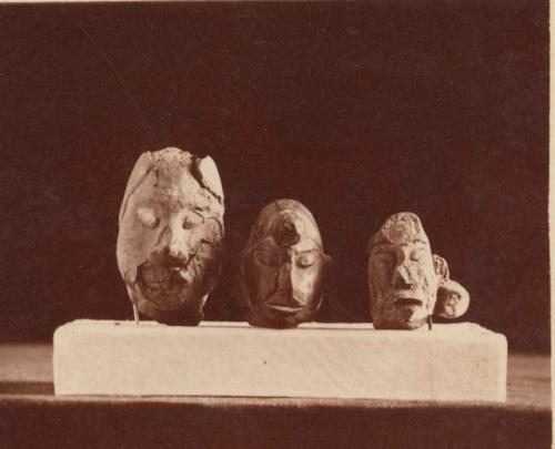 Three pieces of pottery in the shape of human heads.