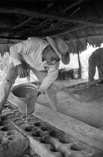 Lisandro Flores pouring panela into molds