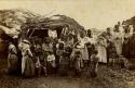Inuit women and children in front of sod house