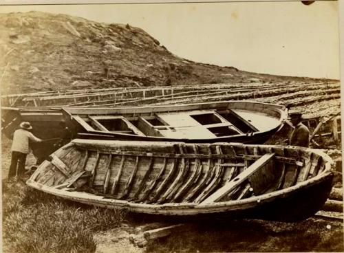 Umiak next to wooden row boat