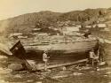 Four men working on wooden plank boat