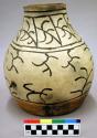 Ceramic jar, black on white exterior, buff cracked base, fire clouded