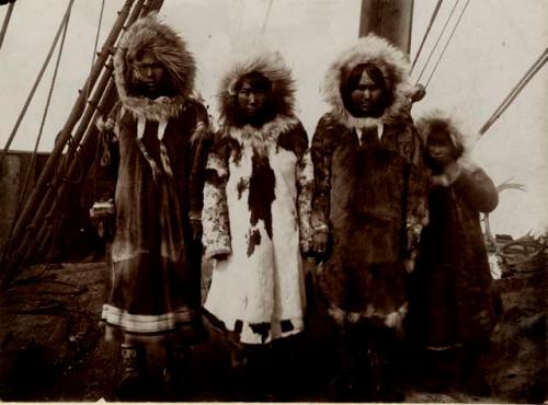 Three Inuit women and a girl wearing fur parkas