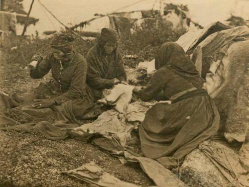 Three women sitting on ground