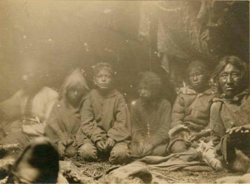 Photo of six people sitting on the ground inside a lodge