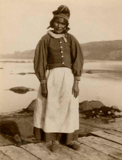 Naskapi woman standing on wooden walkway near river