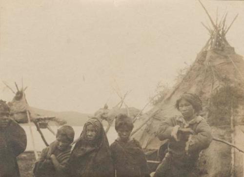 Five children, tepee and platform in background