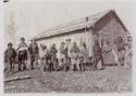 Group of Liard Indians in front of wood cabin