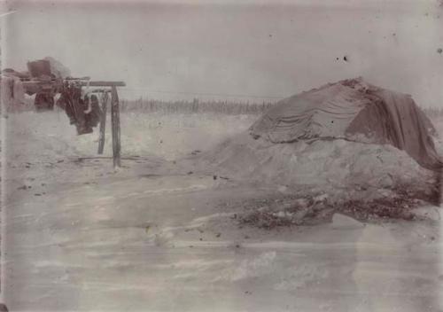 View of tent and pole rack with coats to left. Winter camp