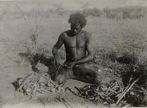 Aboriginal Man Preparing Shredded Bark for String Making