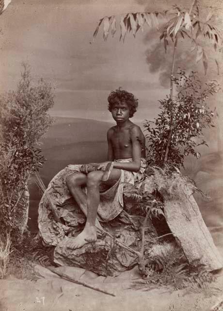 Studio-stage scene of Aboriginal Boy holding Axe