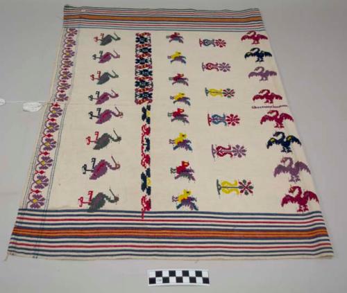 Tzute, woman's multipurpose cloth, white with stripes at the borders and mulicolored birds and flowers in the center