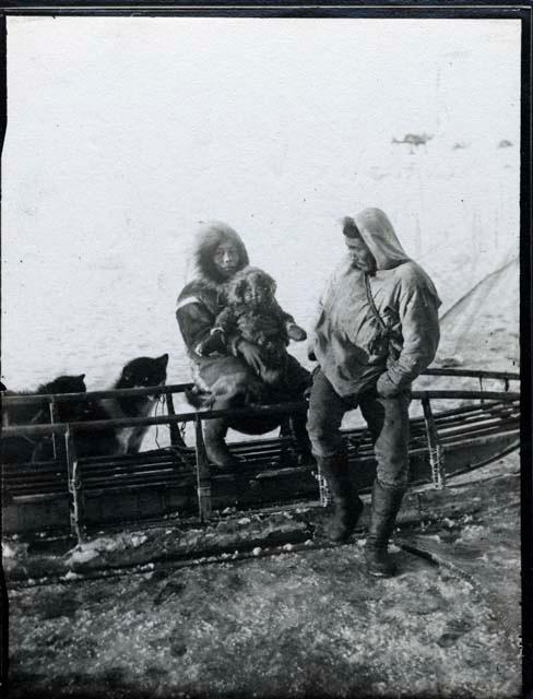 Uikshrak, Tullik, and Nagoroak; man - woman and child leaning against sled.