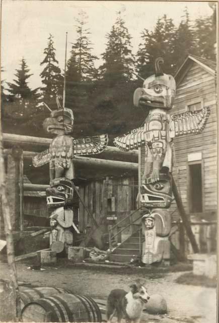 Two totem poles flanking entrance to building.