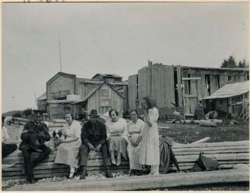 Group of women and men sitting outside village
