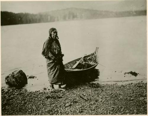 Quatsino woman standing next to canoe in Winter Harbor