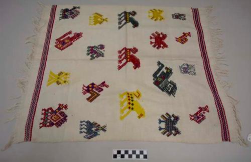 Servilleta, small multipurpose cloth, white with bands of red and blue at ends and large multicolored zoomorphic images in center