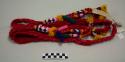 Tocoyal, women's headdress, braided, red with multicolored tufts and geometric designs at the ends