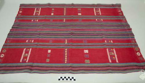 Tzute, women's multipurpose headcloth, two pieces sewn together, red with multicolored stripes in the middle and on the edges, multicolored floral, animal, and geometric images.