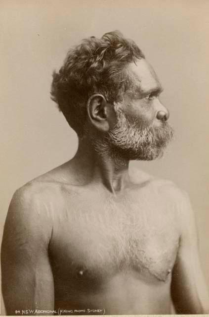 Profile shot of an Aboriginal man with ritual scarification across chest