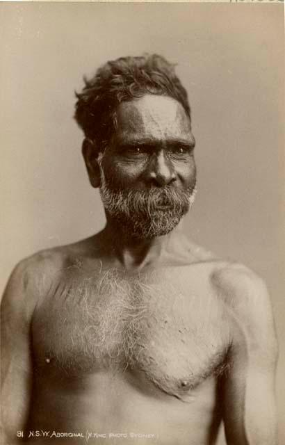 Studio portrait of an Aboriginal man with ritual scarification across chest