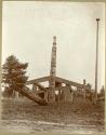 Totem pole standing in front of house frame