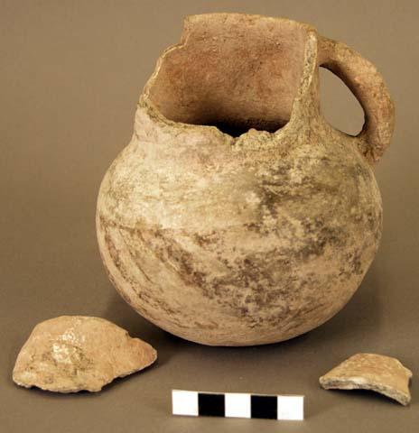 Ceramic pitcher and sherds, red on buff exterior, strap handle, broken neck