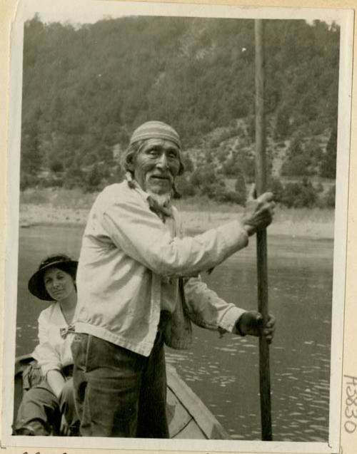 Sandy Bar Bob poling a canoe, with Grace Nicholson as passenger