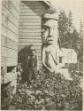 Numnuguamis man standing next to house post