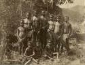 Photo of ten Aboriginal males ranging in age, holding a mix of spears and swords
