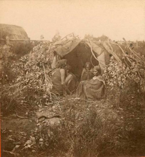 Aboriginal women huddled in a shelter