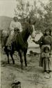 Thompson River Indian man on horseback with woman holding bridle
