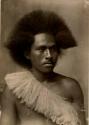Studio portrait of a Fijian man wearing a sash made of plant fiber