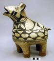 Large pottery animal figurine. Black and buff, red feet.