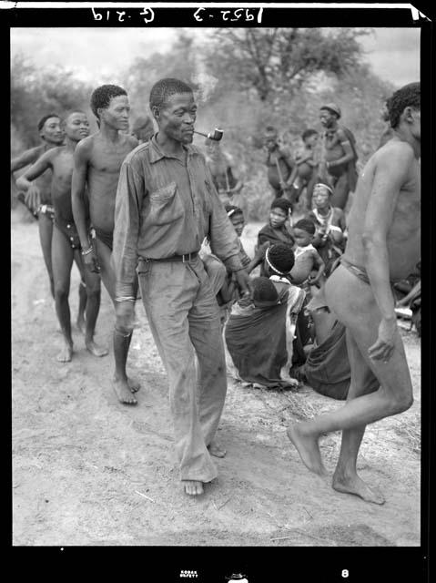 Curing dance for a sick baby at Moremi’s farm; men dancing behind the women, right to left: "/Qui Navel", /Ti!kay wearing Western clothing, //Ao, and Tsamgao (/Ti!kay's son-in-law)