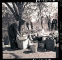 John Namabue washing dishes in the expedition camp kitchen
