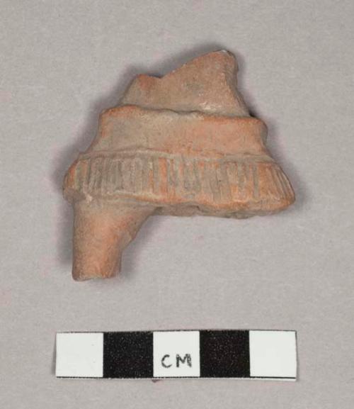 Pottery figurine fragments showing fringed skirts