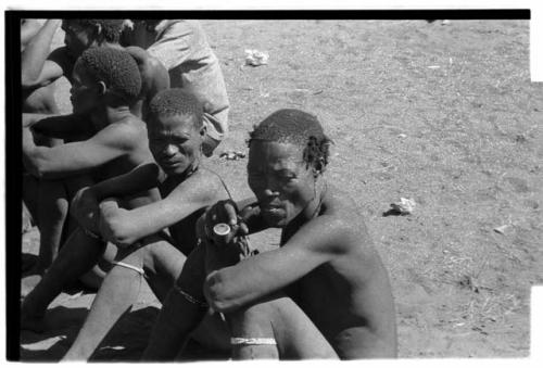 Men sitting, waiting to have their plaster cast face molds made