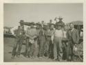 Twelve men posing "participants in potlatch"