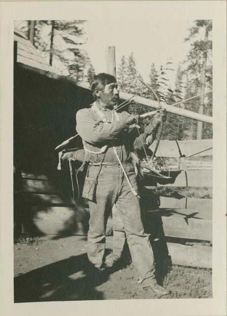 Sampson Grant holding bow and arrow; Burney road, Pitt River