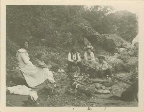 Grace Nicholson, Canyon Tom and Old Dick the boatman sit on shore of the Trinity River with two other women