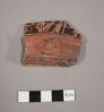 Red and black incised potsherd-face adorno at base