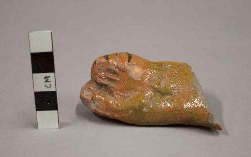 Greenish brown glazed pottery vessel leg with zoomorph head in relief
