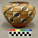 Pottery vessel. Whole surface has white and orange squares divided off by black