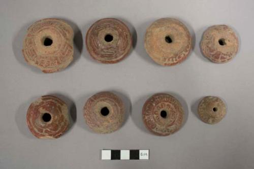 Large red pottery spindle whorls with molded decoration