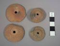 Pottery spindle whorls wth molded decoration