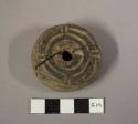 Large stone spindle whorl with design on one side